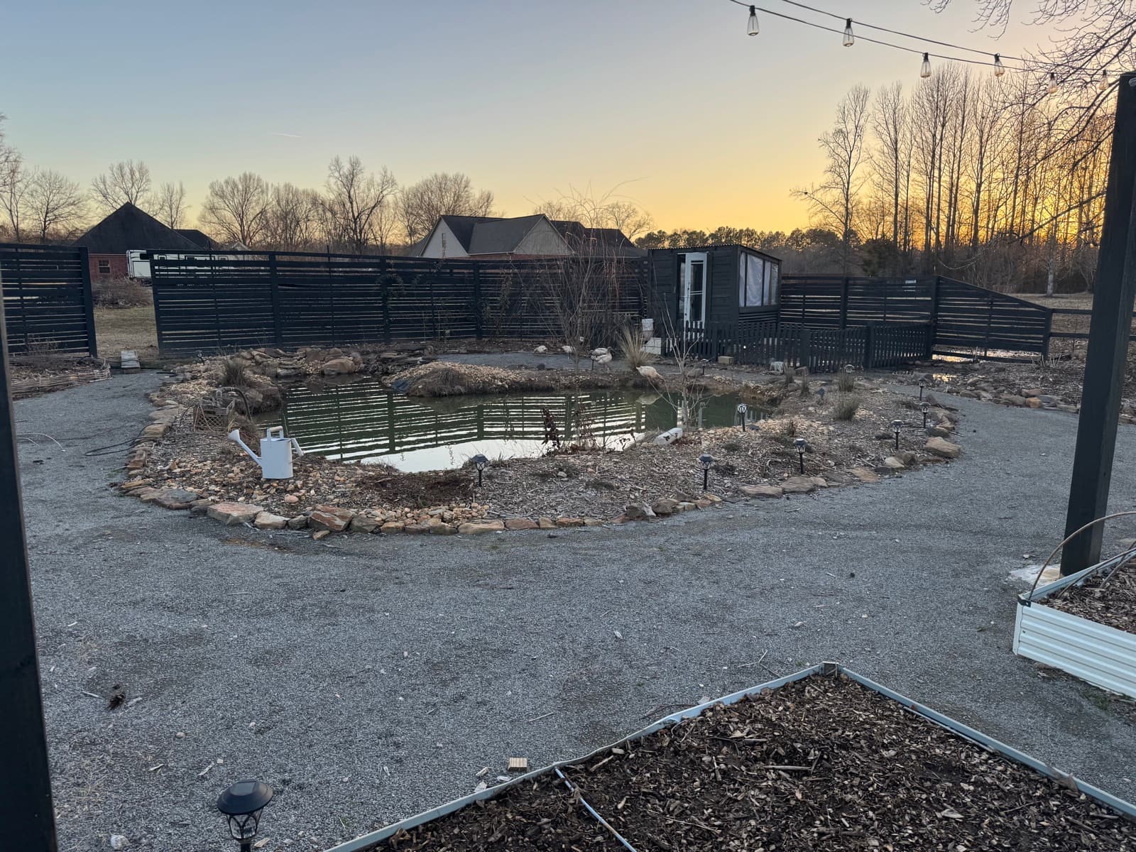 The farm at sunset with pond and string lights