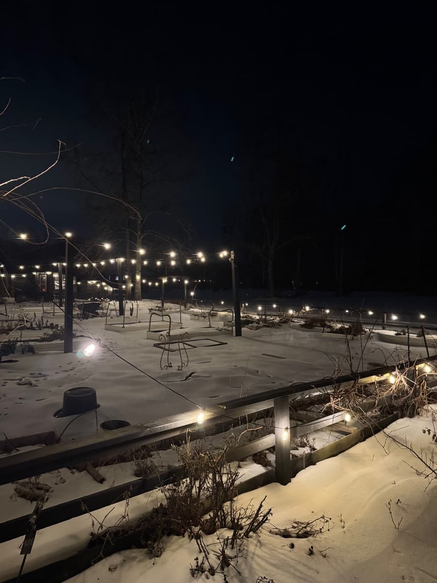 The farm in winter with string lights and snow