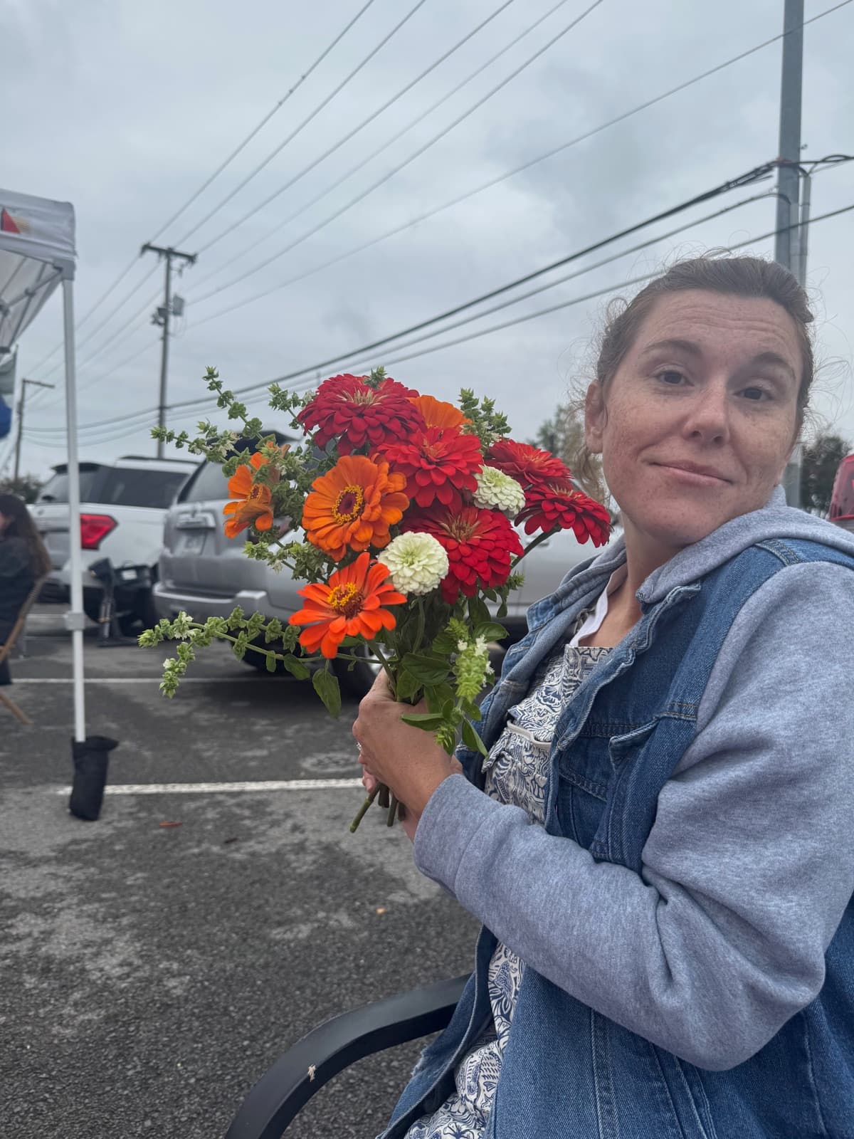 Lauren holding a colorful bouquet at the farmers market